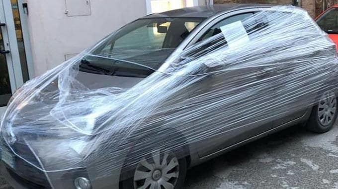 Gli parcheggiano l'auto davanti al negozio, lui la incarta nel cellophane